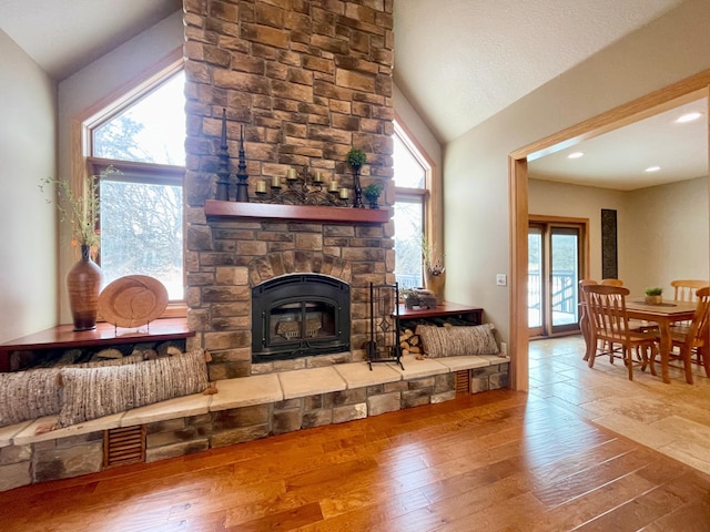 living room featuring lofted ceiling, hardwood / wood-style floors, and a fireplace