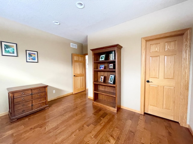 interior space with hardwood / wood-style floors and a textured ceiling