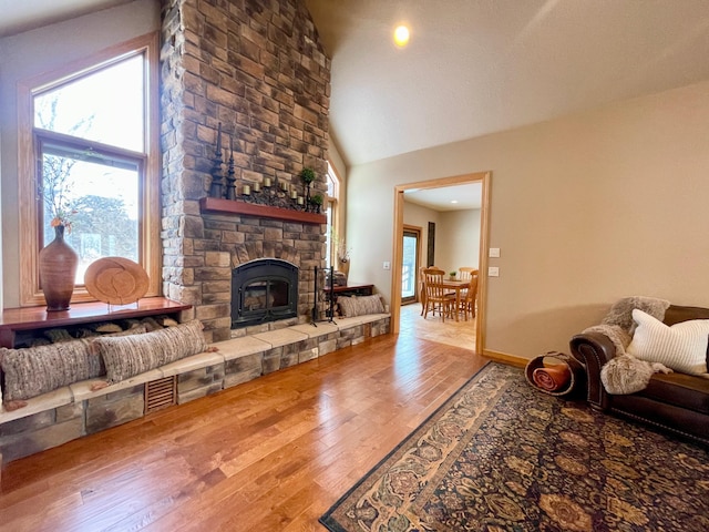 living room with high vaulted ceiling, hardwood / wood-style floors, and a fireplace