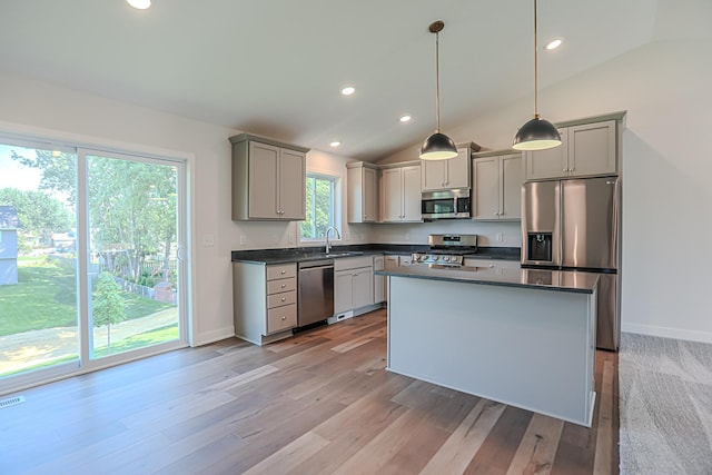 kitchen with decorative light fixtures, lofted ceiling, gray cabinetry, and stainless steel appliances