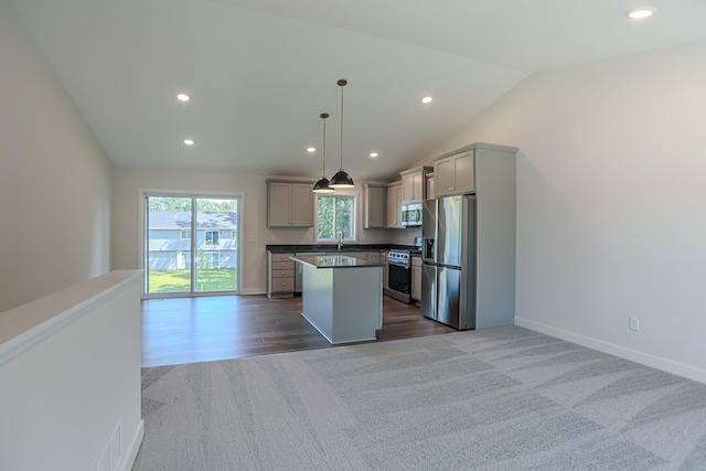 kitchen featuring decorative light fixtures, gray cabinets, stainless steel appliances, and a center island