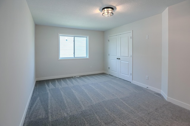 unfurnished bedroom featuring carpet, a closet, and a textured ceiling