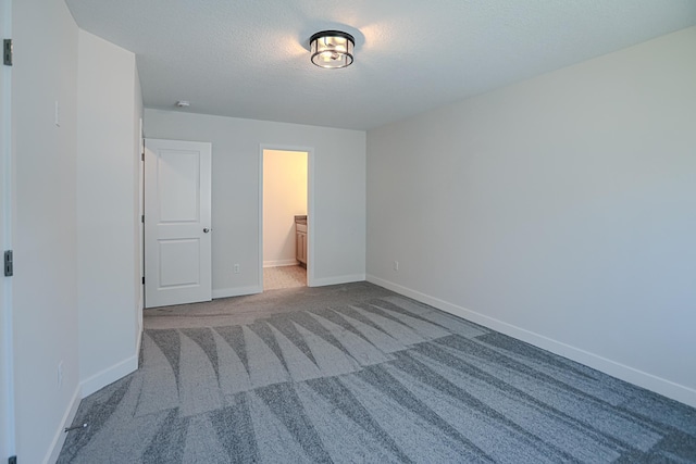 carpeted spare room featuring a textured ceiling