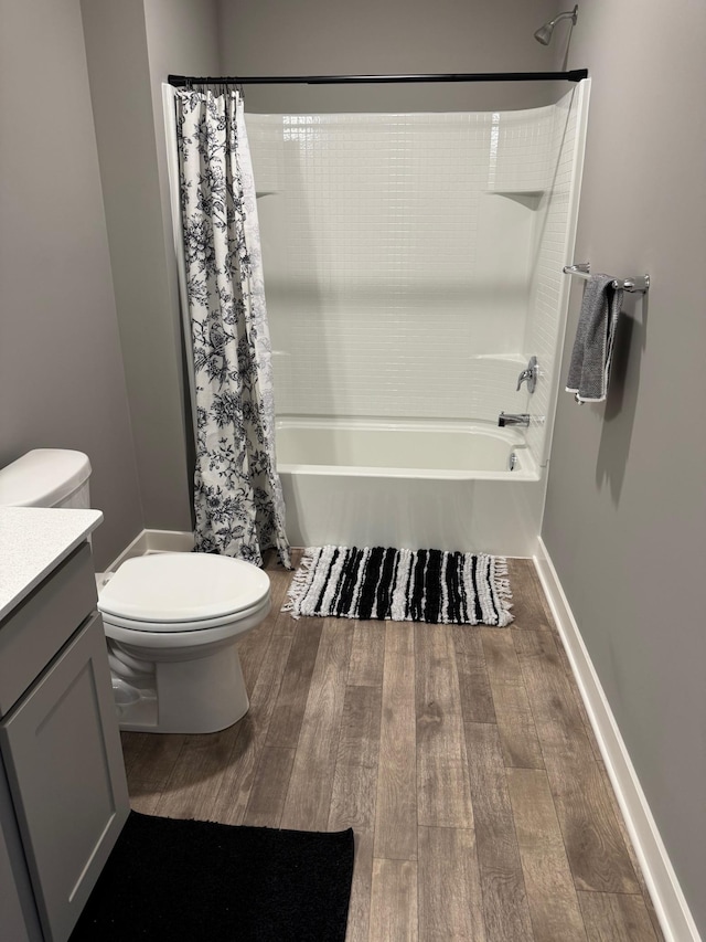 full bathroom with hardwood / wood-style flooring, shower / bath combo with shower curtain, vanity, and toilet