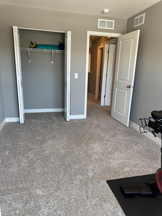 bedroom with a textured ceiling, a closet, and carpet flooring