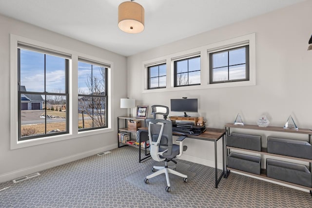 office area with carpet flooring, visible vents, and baseboards