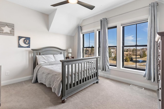 carpeted bedroom with a ceiling fan, visible vents, vaulted ceiling, and baseboards