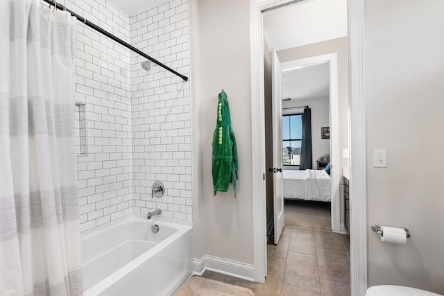 ensuite bathroom featuring baseboards, ensuite bath, shower / bath combo with shower curtain, and tile patterned floors