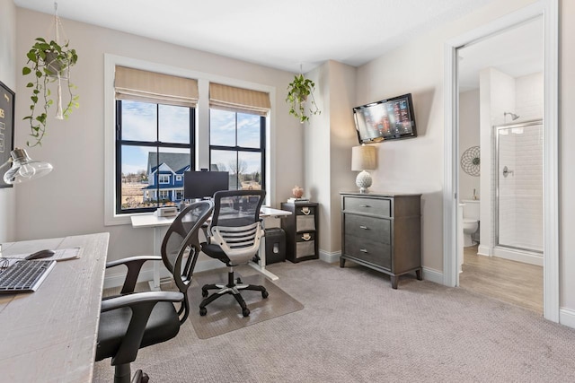 home office featuring light carpet and baseboards