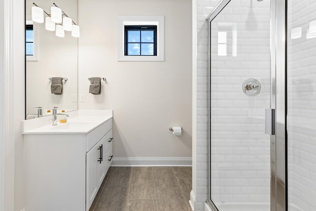 full bath with a shower stall, baseboards, and vanity