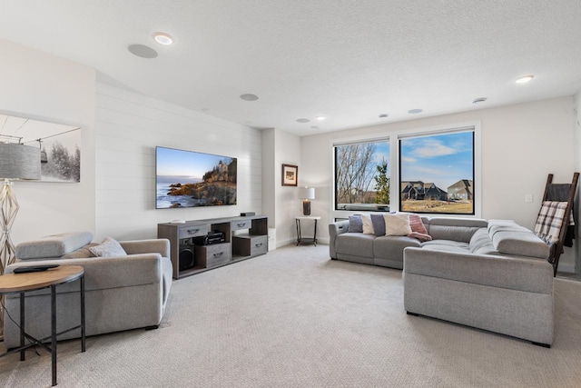 carpeted living area with recessed lighting, a textured ceiling, and baseboards