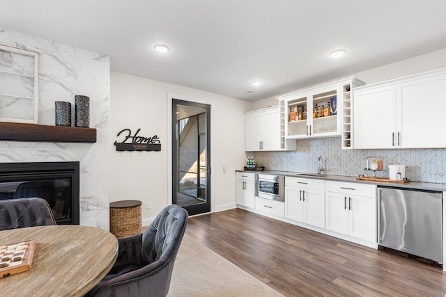 kitchen with dark wood-style floors, stainless steel microwave, fridge, open shelves, and a sink