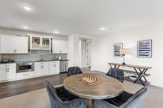 dining space featuring recessed lighting, dark wood-style flooring, indoor wet bar, and baseboards