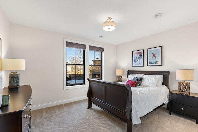 bedroom with light carpet and baseboards