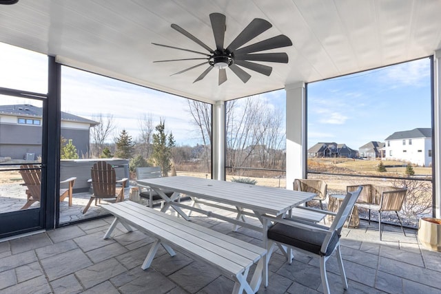 sunroom / solarium featuring a ceiling fan