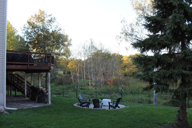 view of yard featuring a wooden deck, an outdoor fire pit, and a patio