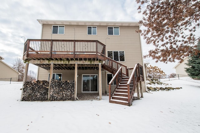 snow covered rear of property featuring a deck