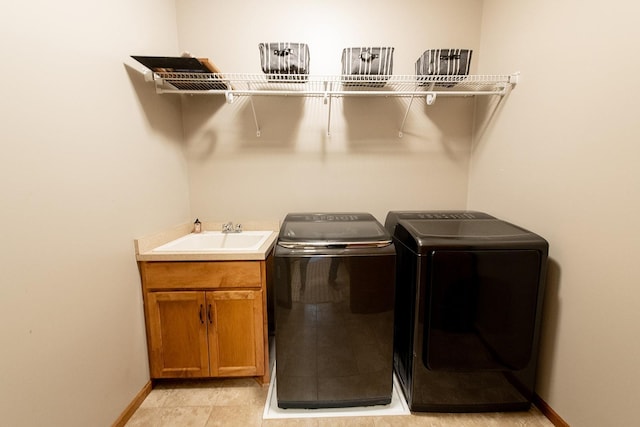 laundry area with cabinets, sink, separate washer and dryer, and light tile patterned flooring