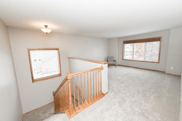 interior space featuring a textured ceiling and light colored carpet