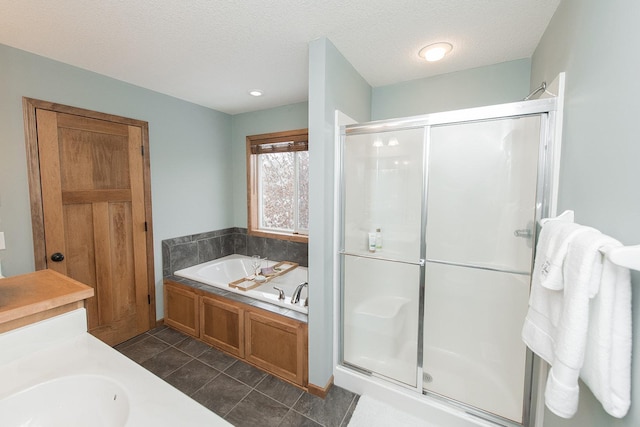 bathroom with sink, a textured ceiling, and separate shower and tub