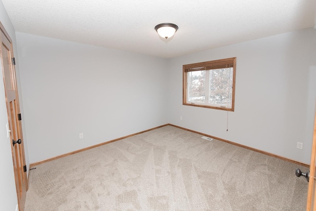 carpeted spare room featuring a textured ceiling