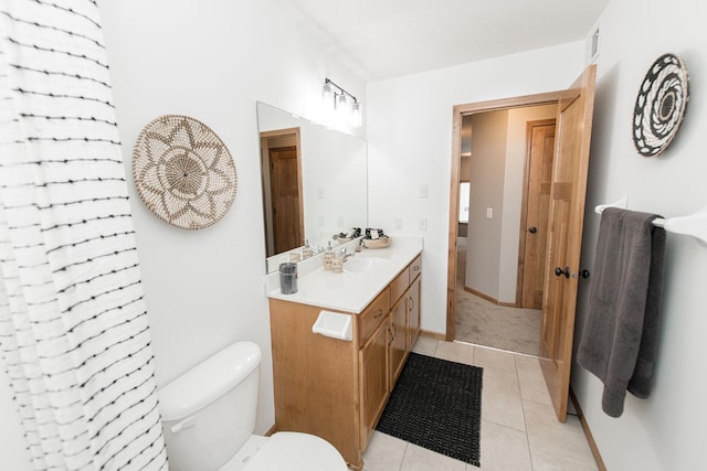 bathroom with toilet, tile patterned floors, and vanity