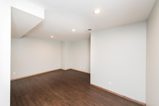 unfurnished room featuring dark hardwood / wood-style floors and a textured ceiling