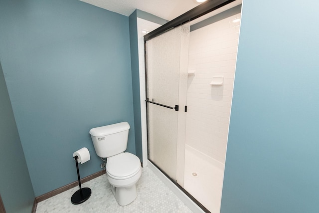 bathroom featuring toilet, tile patterned flooring, a textured ceiling, and a shower with door