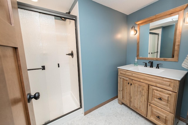 bathroom featuring a shower with shower door and vanity