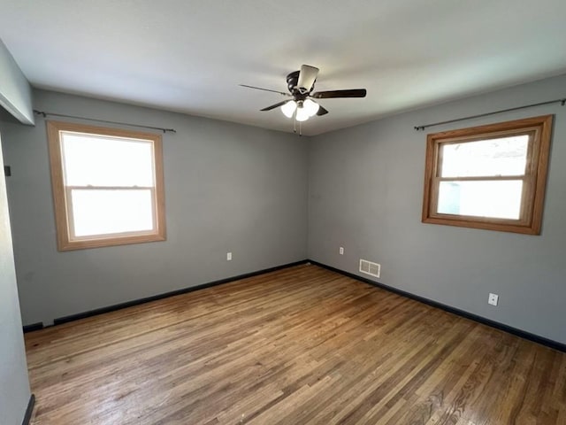 unfurnished room with ceiling fan, a healthy amount of sunlight, and light hardwood / wood-style floors