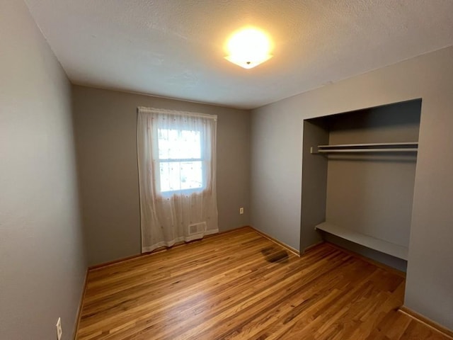 unfurnished bedroom featuring a closet and light hardwood / wood-style flooring