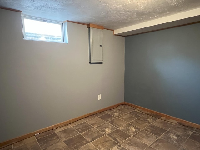 basement featuring a textured ceiling and electric panel