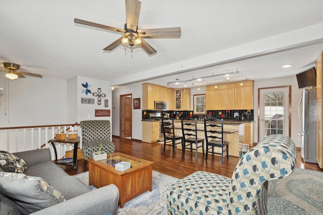 living room with hardwood / wood-style flooring, ceiling fan, and a textured ceiling