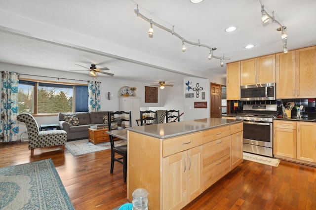 kitchen with a breakfast bar, light brown cabinets, dark hardwood / wood-style flooring, a kitchen island, and stainless steel appliances