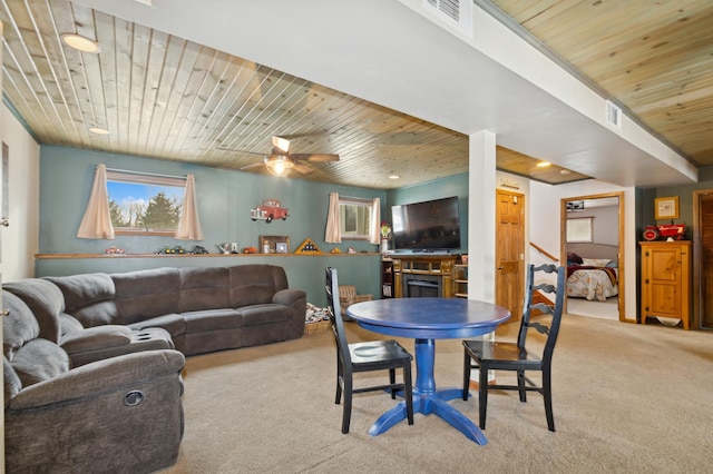 carpeted dining space with wood ceiling and a fireplace