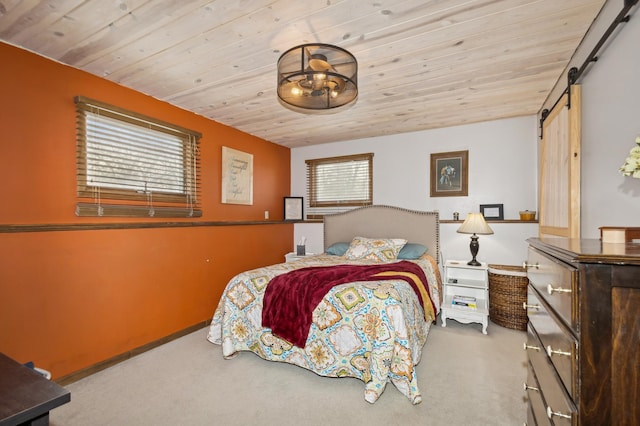 carpeted bedroom with wooden ceiling and a barn door