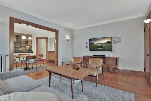 living room featuring crown molding, an inviting chandelier, and hardwood / wood-style flooring