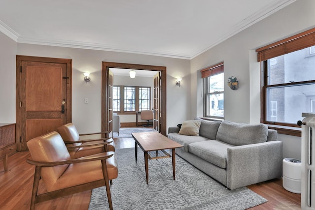 living room featuring a wealth of natural light, baseboards, light wood-style floors, and ornamental molding