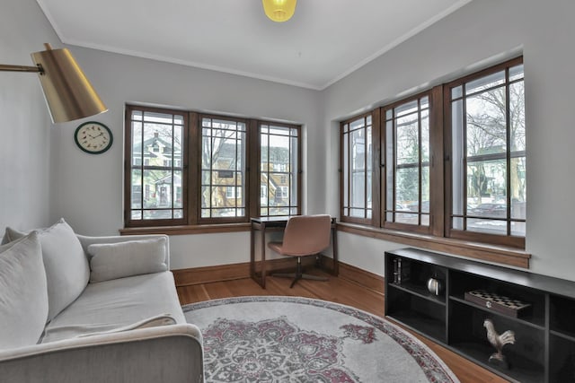 interior space with crown molding, wood finished floors, baseboards, and a healthy amount of sunlight