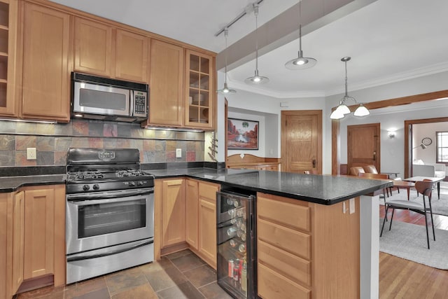 kitchen with tasteful backsplash, dark countertops, wine cooler, appliances with stainless steel finishes, and a peninsula