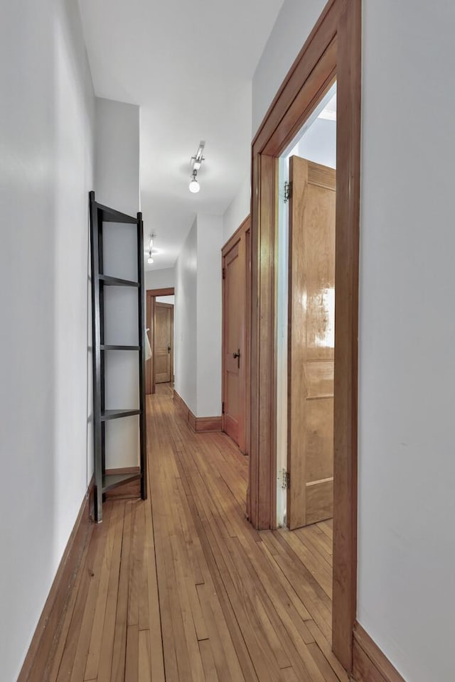 hall featuring baseboards and light wood-style floors