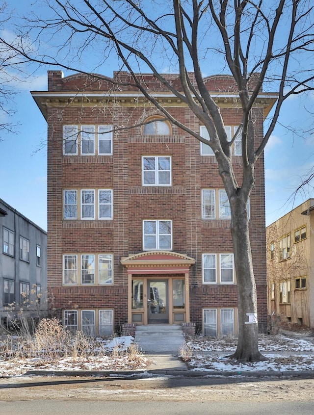 view of front of home with brick siding and a chimney