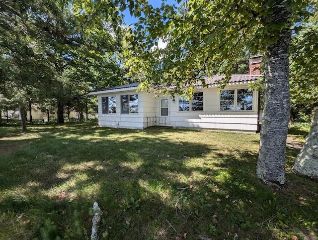 rear view of property with a lawn