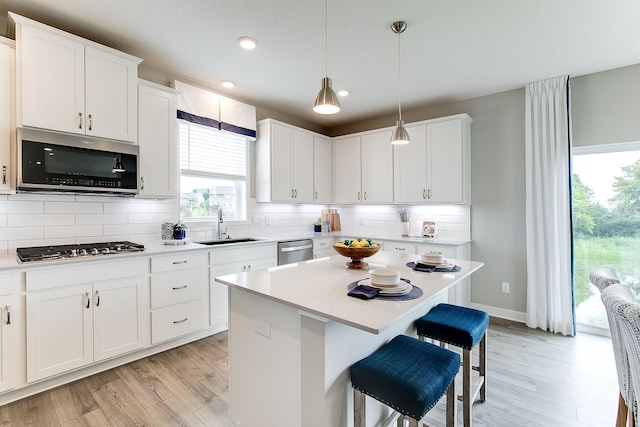 kitchen featuring sink, white cabinetry, appliances with stainless steel finishes, and a kitchen island