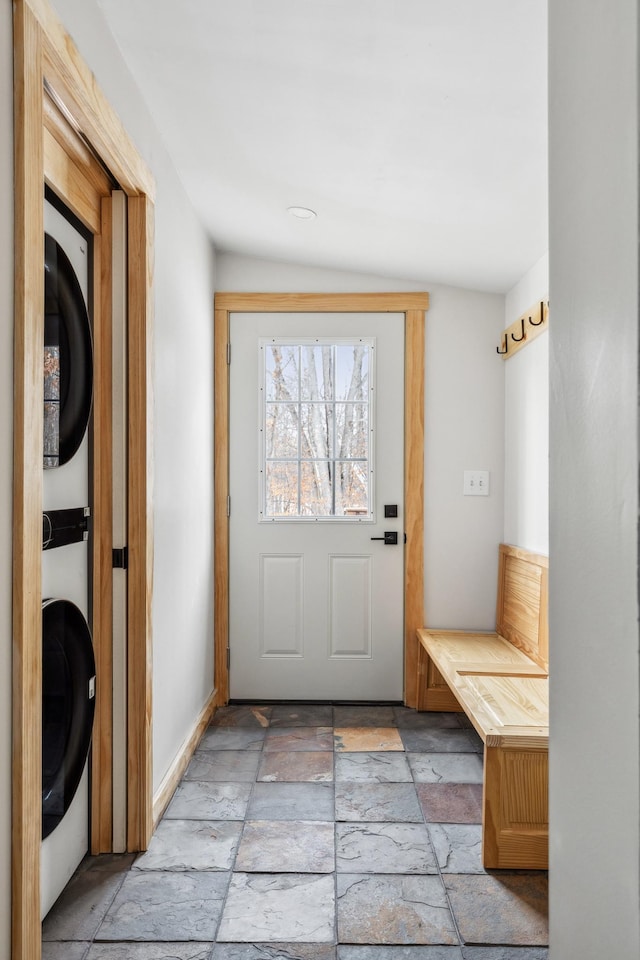 mudroom featuring vaulted ceiling and stacked washer / drying machine