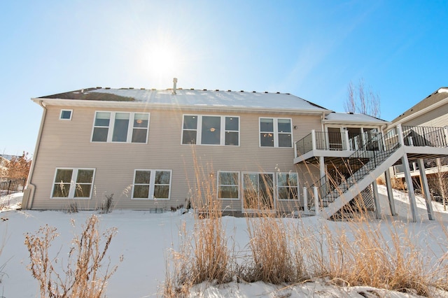 view of snow covered back of property