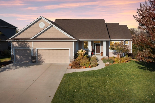 view of front of house with a garage and a lawn