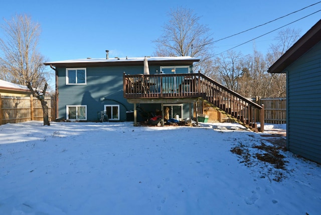 snow covered rear of property with a wooden deck