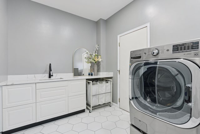 washroom featuring washer / clothes dryer, light tile patterned floors, cabinets, and sink