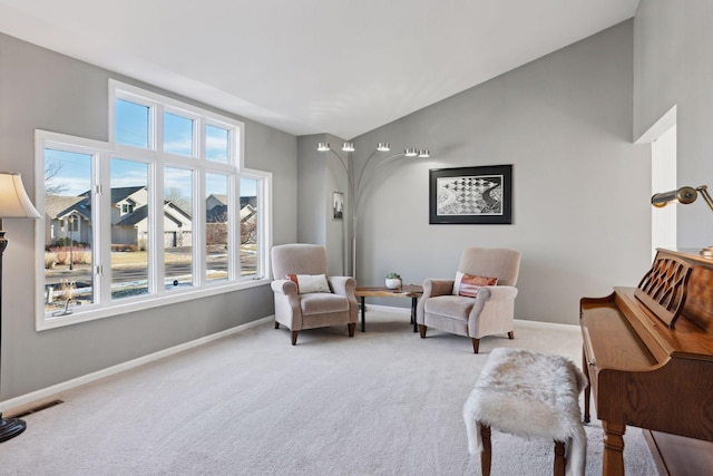 sitting room featuring light colored carpet and lofted ceiling